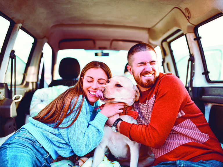 family-smiling-with-dog-in-car